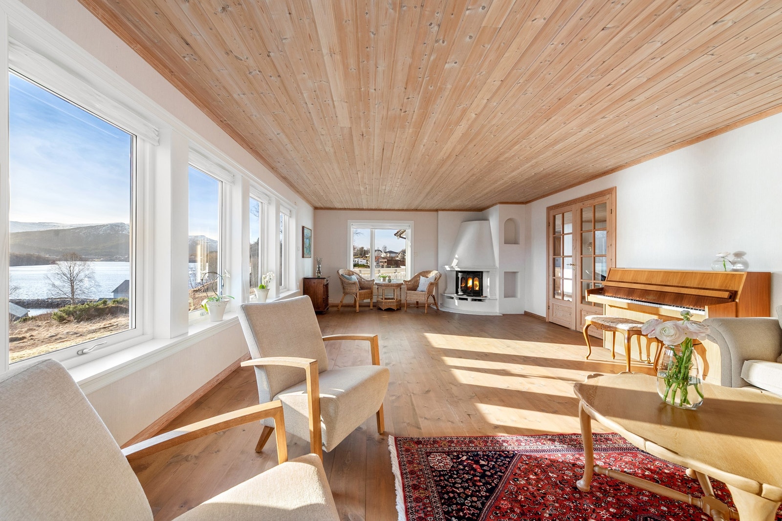Stor stue med lyse overflater og store vindusflater mot syd og vest som gir godt med lysinnslipp i stuen.
Murt peis med innsats i stuen Galleribilde