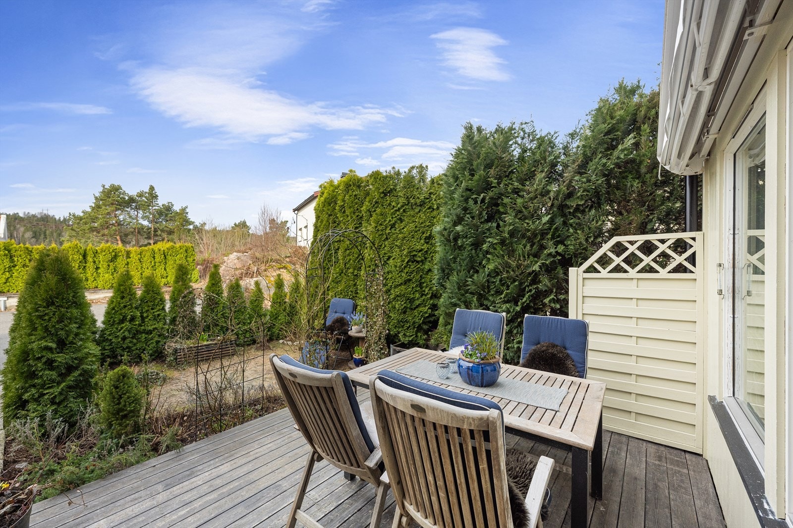 Terrassen er et ideelt sted for utemøbler og avslapning, omkranset av en levegg i tre. Galleribilde