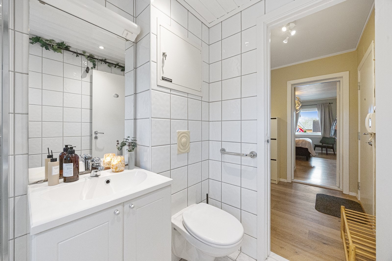 Badet er innredet med dusjkabinett, veggmontert toalett og servantinnredning med skap og speil. Det er opplegg til vaskemaskin. Galleribilde