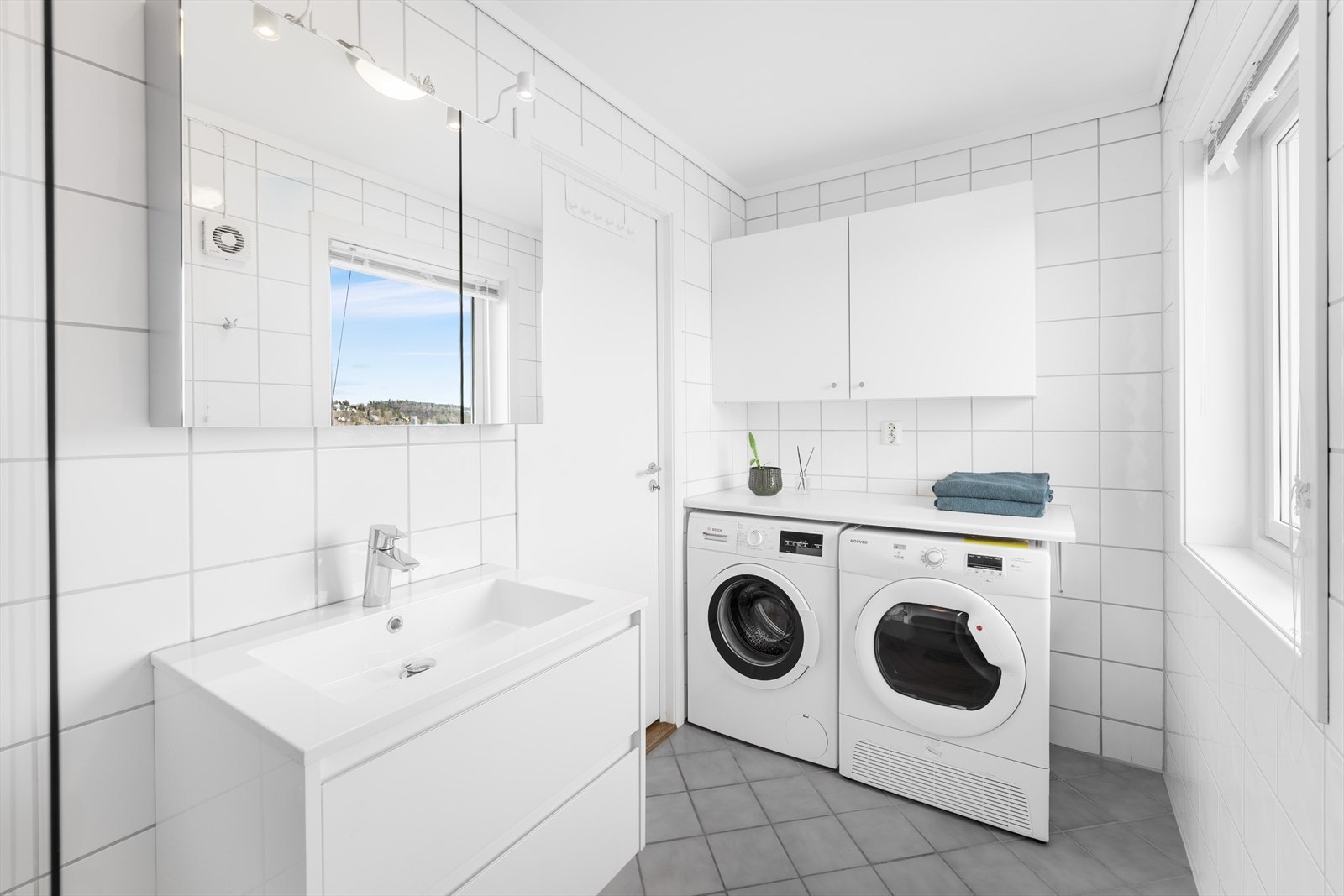 Fliselagt pent bad med nyere innredning og speilskap. Galleribilde