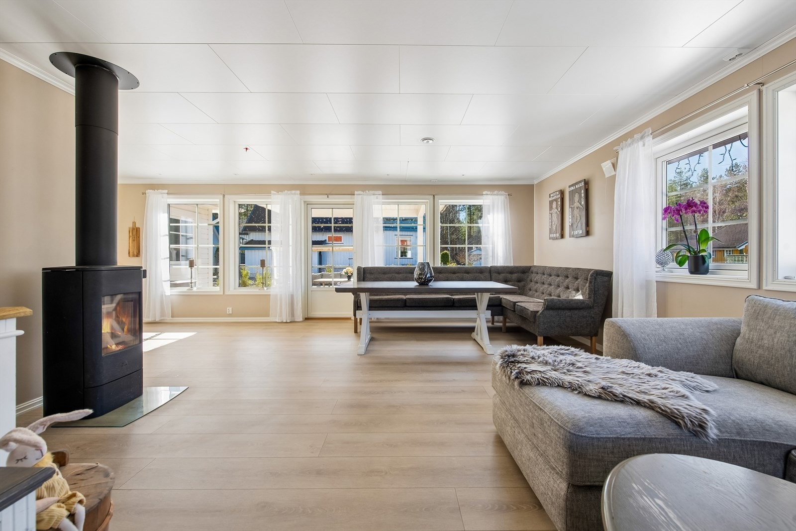 Store vinduer slipper godt inn med dagslys i stuen. Boligen har peisovn i tillegg til vannbåren varme. Galleribilde