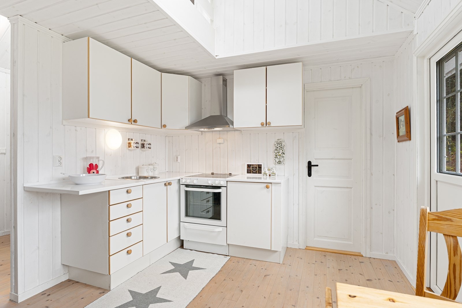 Det er frittstående hvitevarer og kjøkkenventilator med avtrekk ut Galleribilde