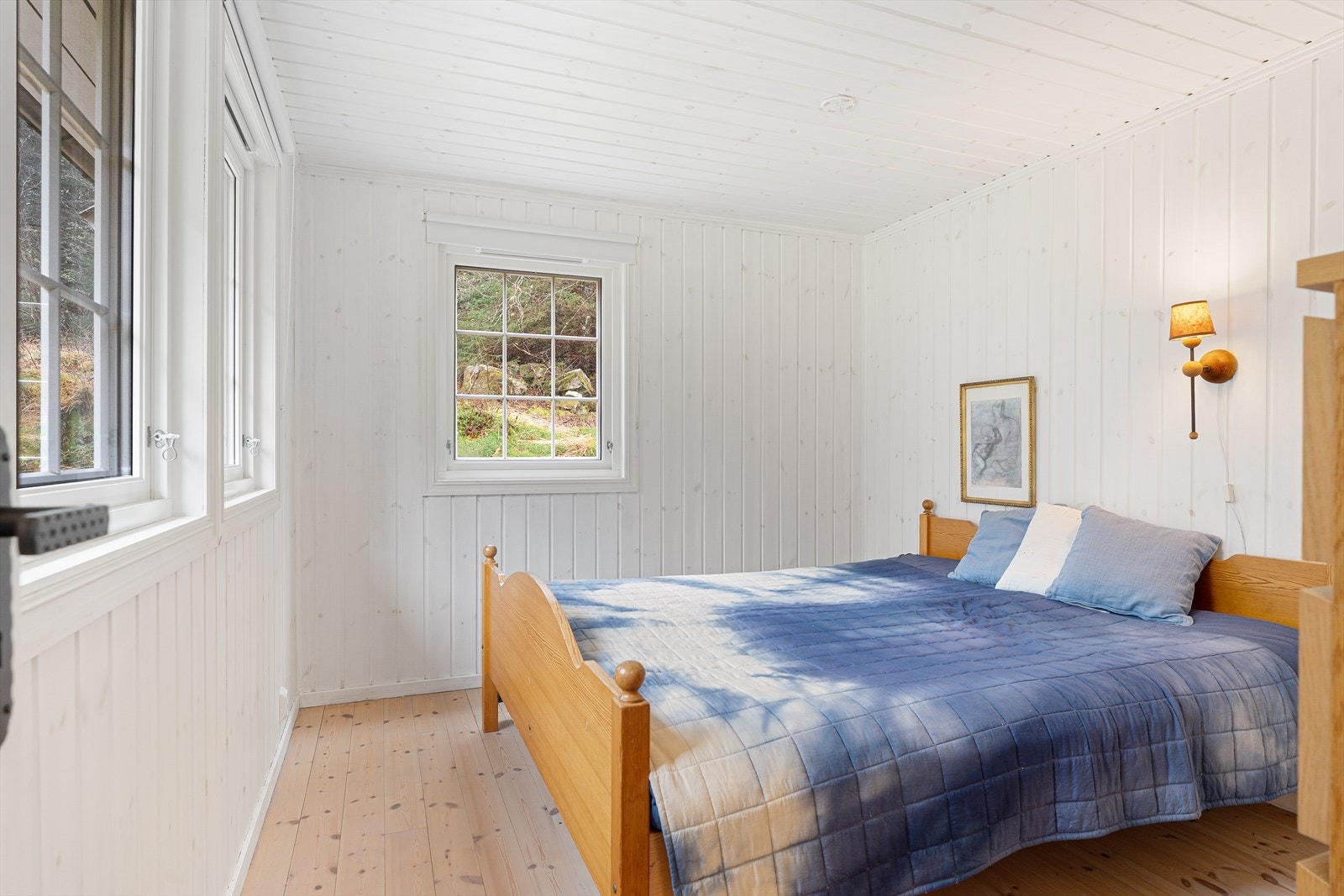 Romslig soverom med plass til både dobbeltseng og tilhørende nattbord Galleribilde