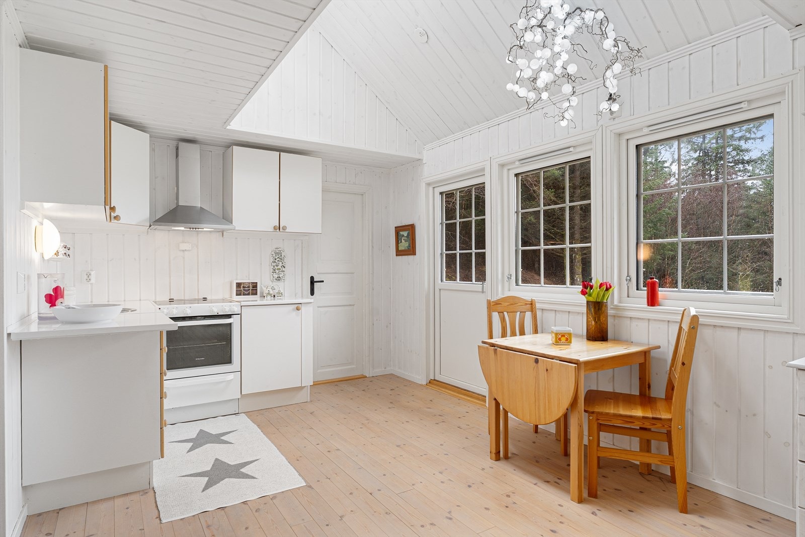 Her får du et pent kjøkken med hvite fronter og laminat benkeplate med nedfelt servant Galleribilde