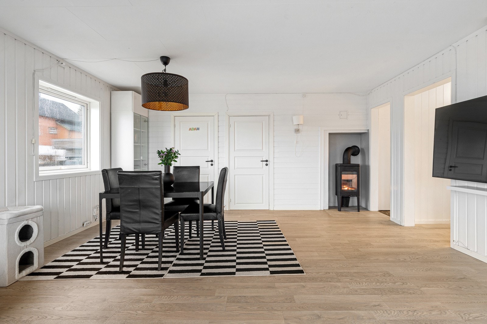 Stuen fremstår som lys og trivelig, og har også vedfyring