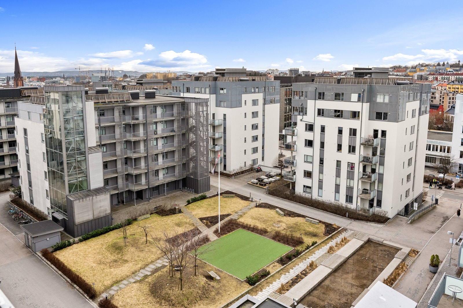 Sameiets flotte gårdsrom med plen og beplantning. Galleribilde