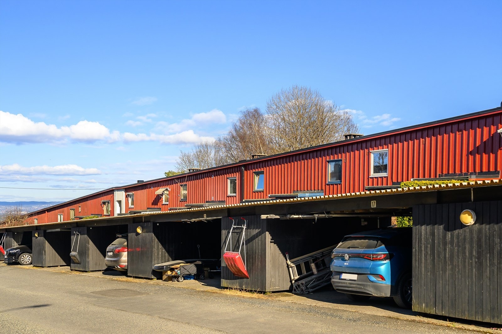 Parkering i carport tilknyttet boligen. Carporten er oppført i rekke med tilhørende bod. Galleribilde