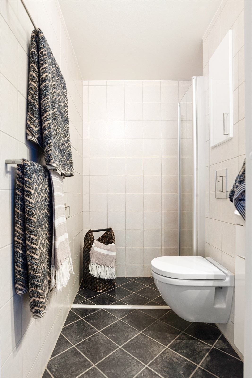 Badet, som ligger i 2. etasje, er fra 2008 og har flislagte vegger og gulv med elektriske varmekabler. Rommet er innredet med servant, veggmontert toalett og dusjløsning med glassvegger. Galleribilde