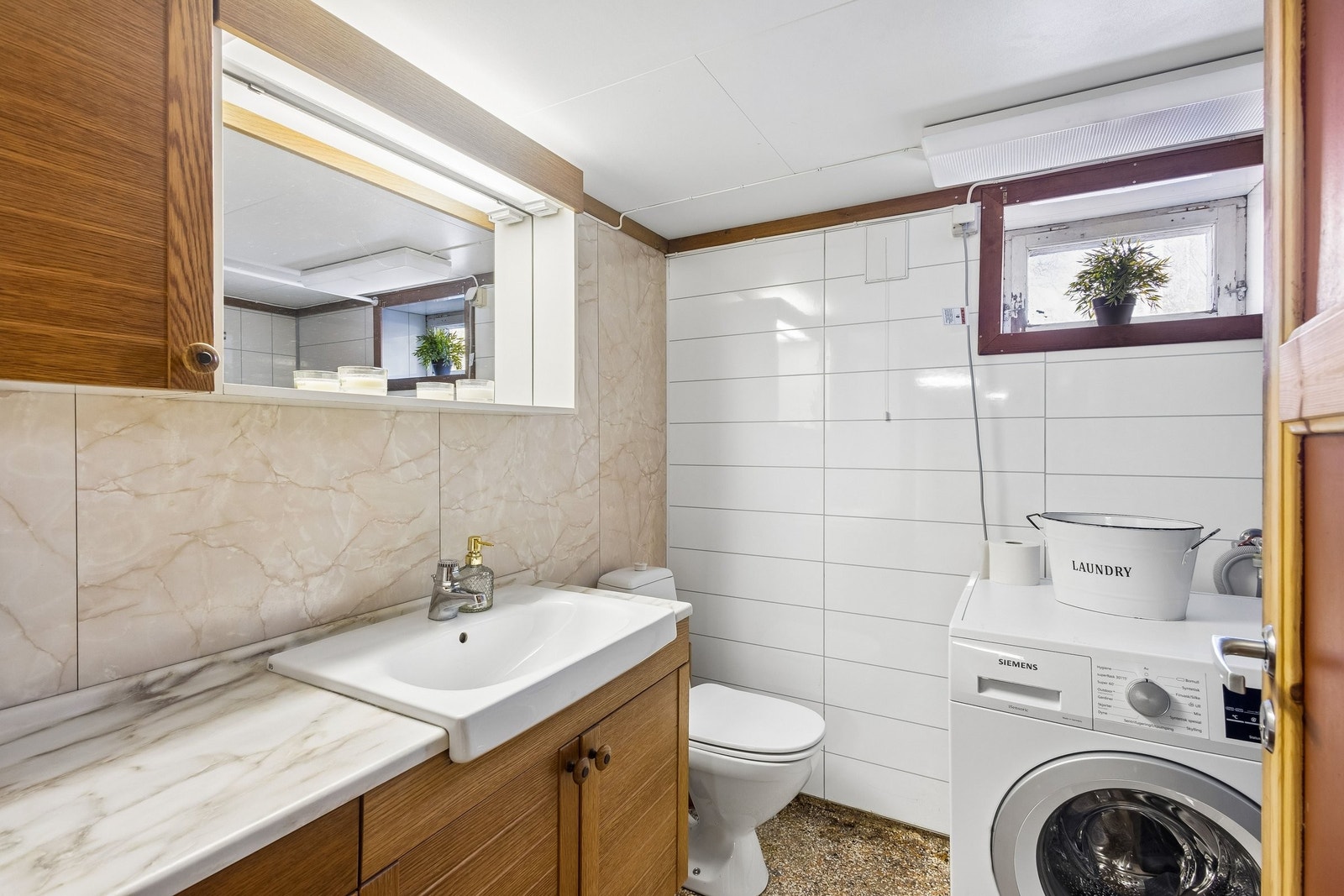 Bad i kjeller med badekar, dusj og vaskemaskin Galleribilde