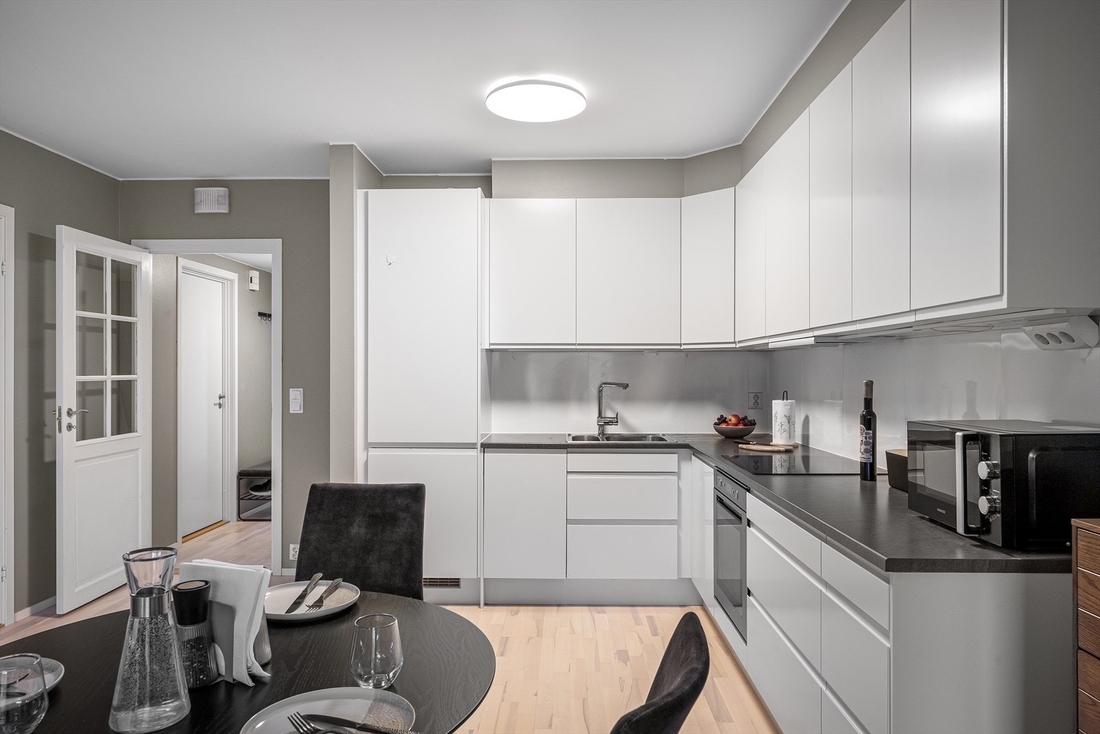 Tidløst og pent kjøkken fra Norema i pen kontrast til tidsriktige malte toner på veggene. Praktisk utforming med rikelig benke- og skapplass. Galleribilde