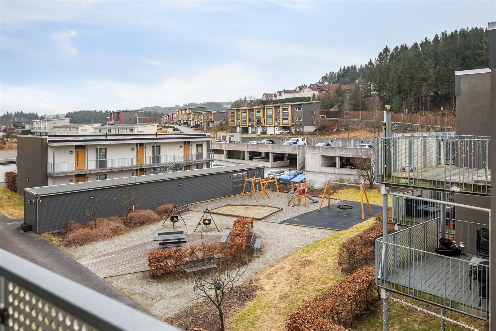 Fra terrassen har du utsikt mot de hyggelige fellesområdene i midten, som inkluderer sittegrupper og lekeplass. Galleribilde