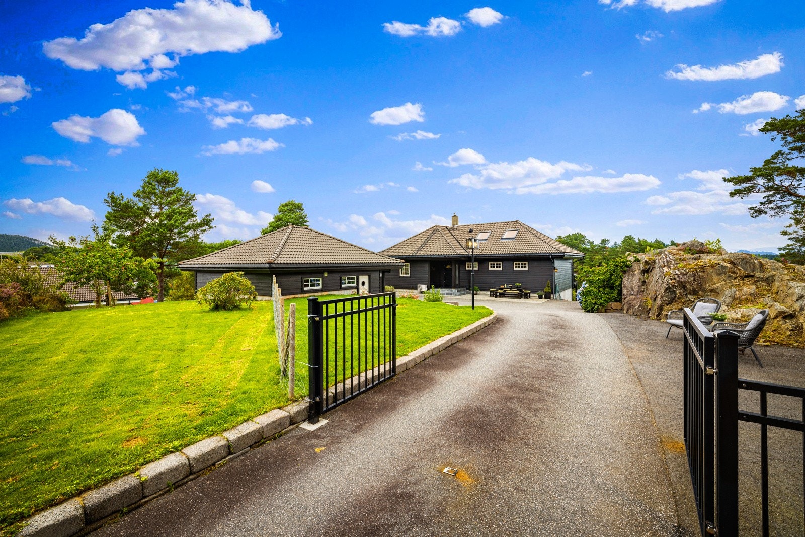 Flott innkjørsel og gårdsplass som er asfaltert. Galleribilde