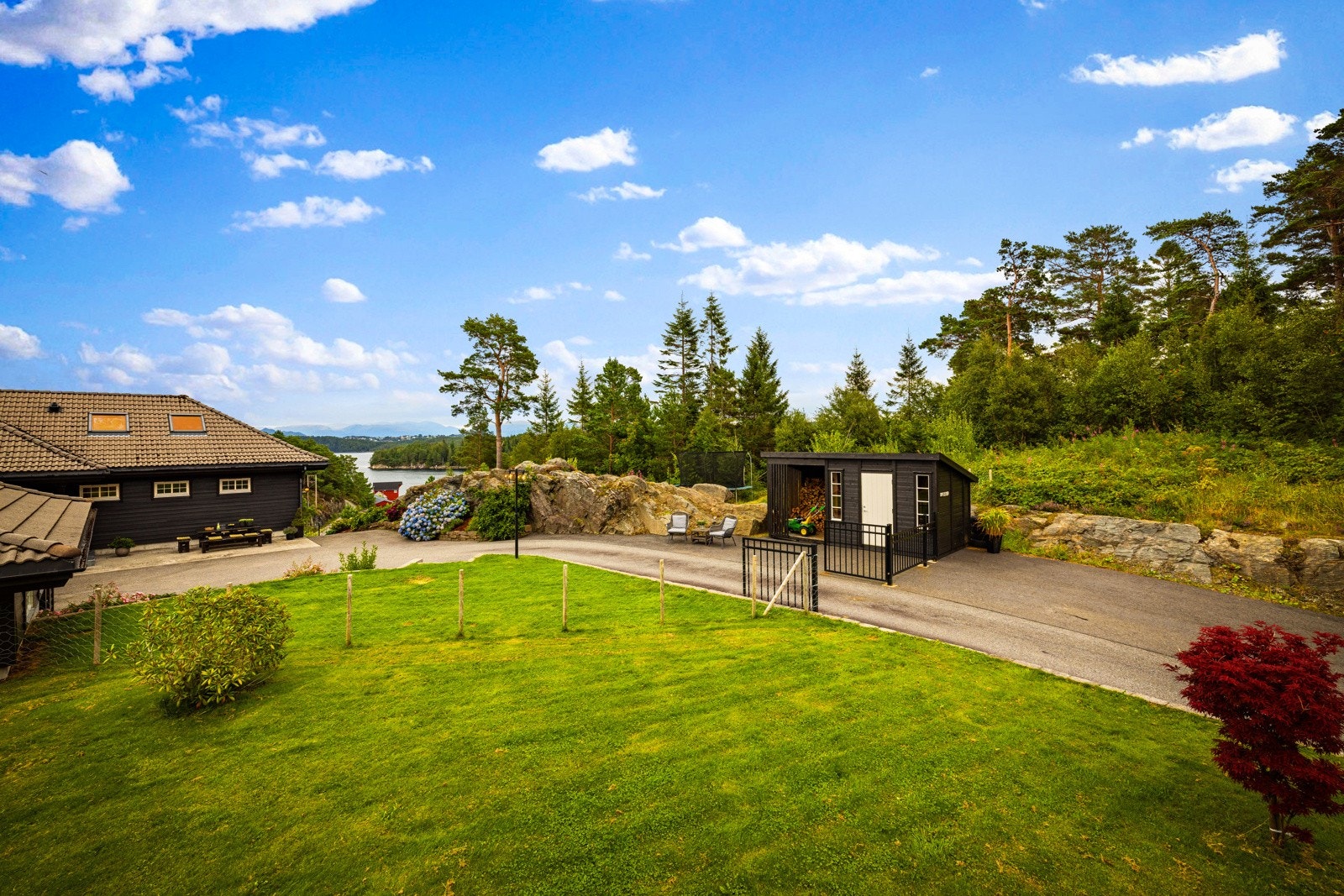 Tomten har både plener, bed, prydbusker, samt noe naturtomt. Galleribilde