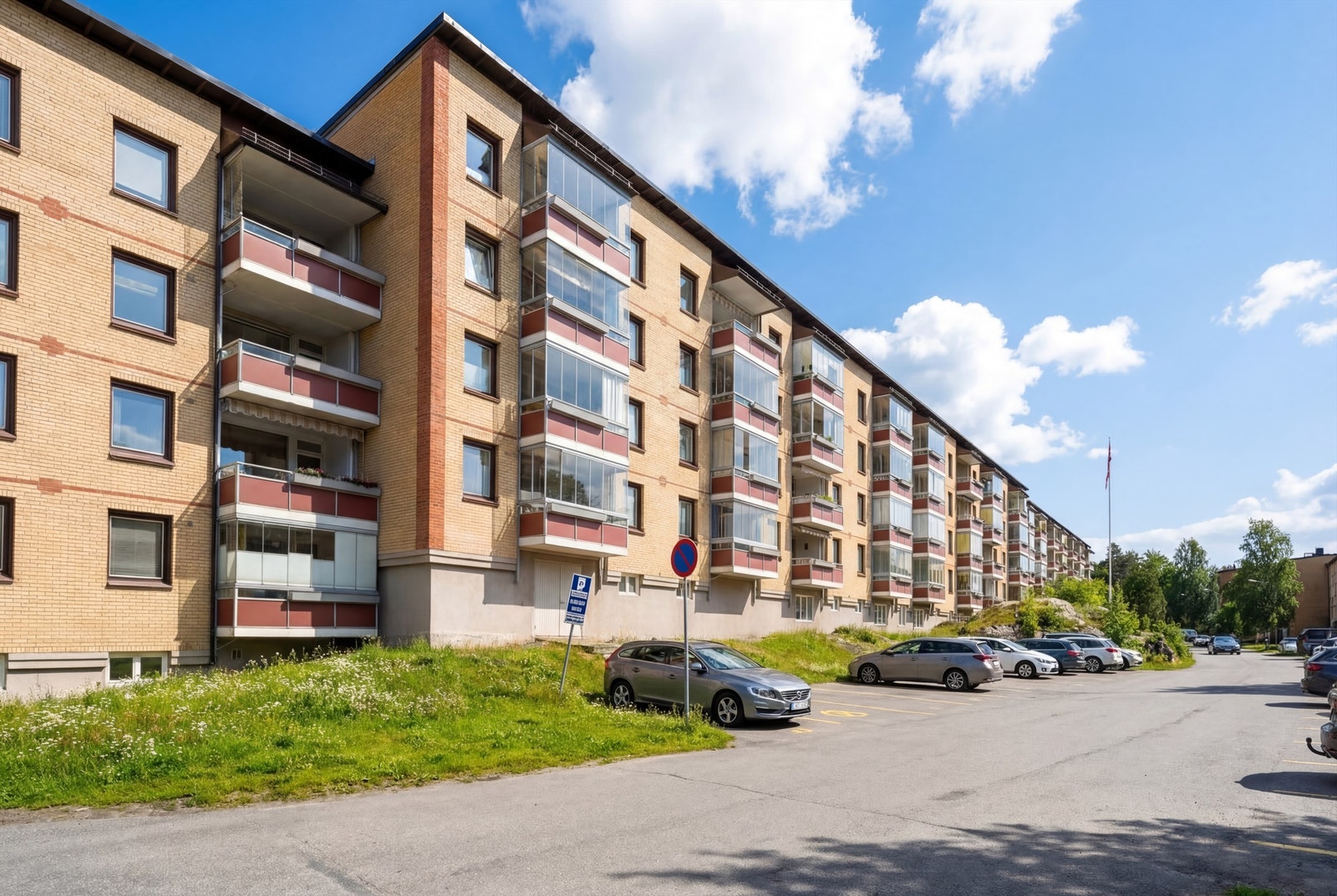 Fasaden sett fra balkong siden, sommerstid.
Borettslaget tilbyr parkeringsplasser etter venteliste, og det er tilgang til elbillading. Galleribilde