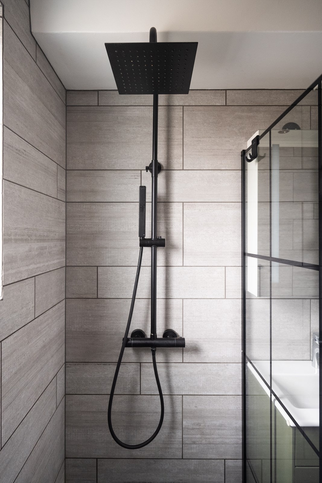 Dusjsonen har en kombinert hånd- og regndusj, skjermet av en glassvegg. Galleribilde