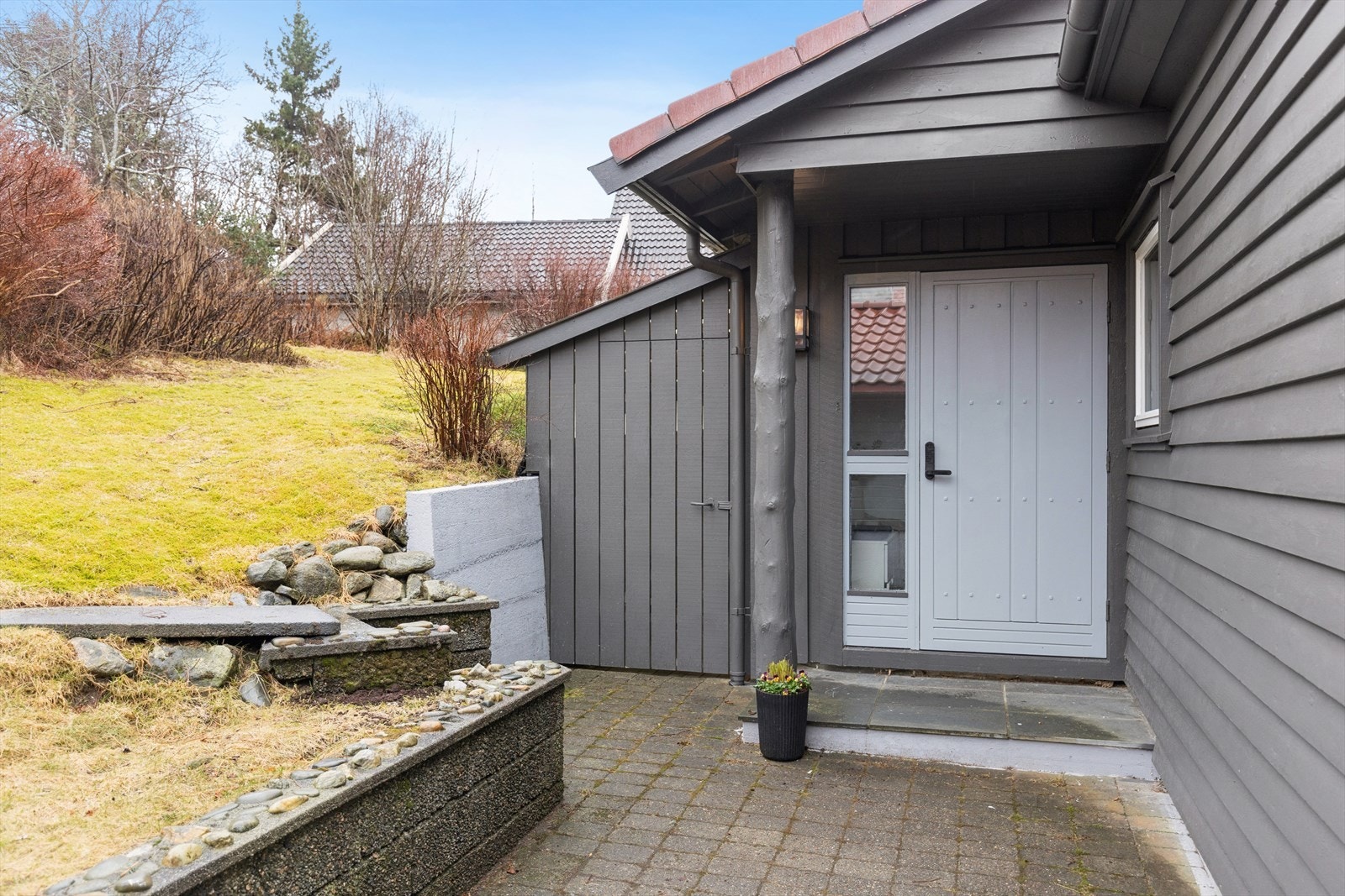 Overbygd inngangsparti med vedskjul ved siden av (tilbygg med vedskjul er ikke byggemeldt og godkjent). Galleribilde