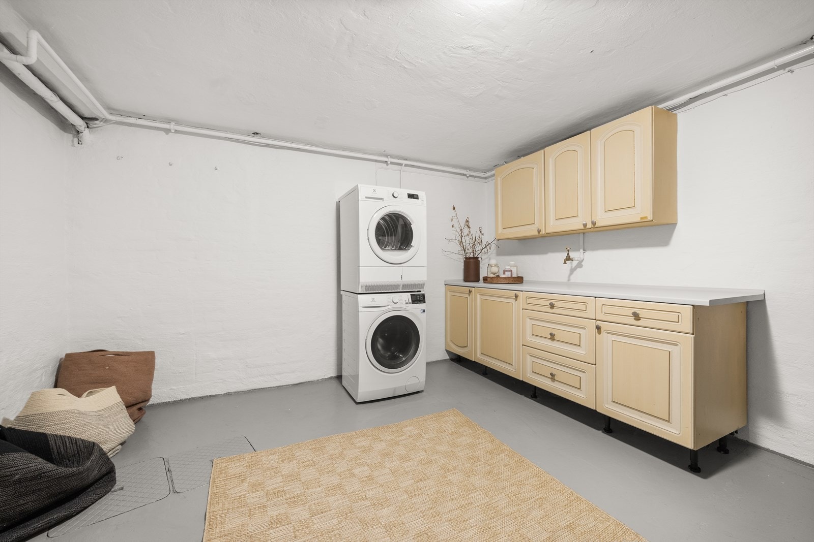 Meget romslig og praktisk vaskekjeller med innredning for oppbevaring og opplegg for vaskemaskin og tørketrommel Galleribilde