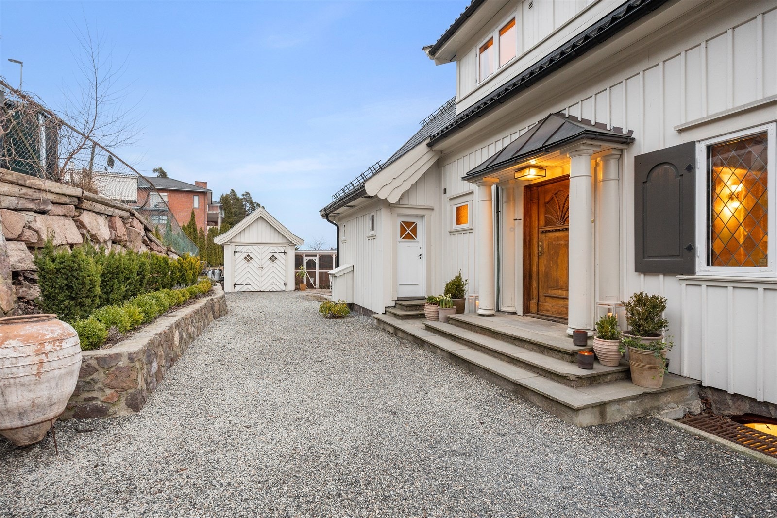 Flott opparbeidet gårdsplass med støttemurer i naturstein og diverse beplantning Galleribilde