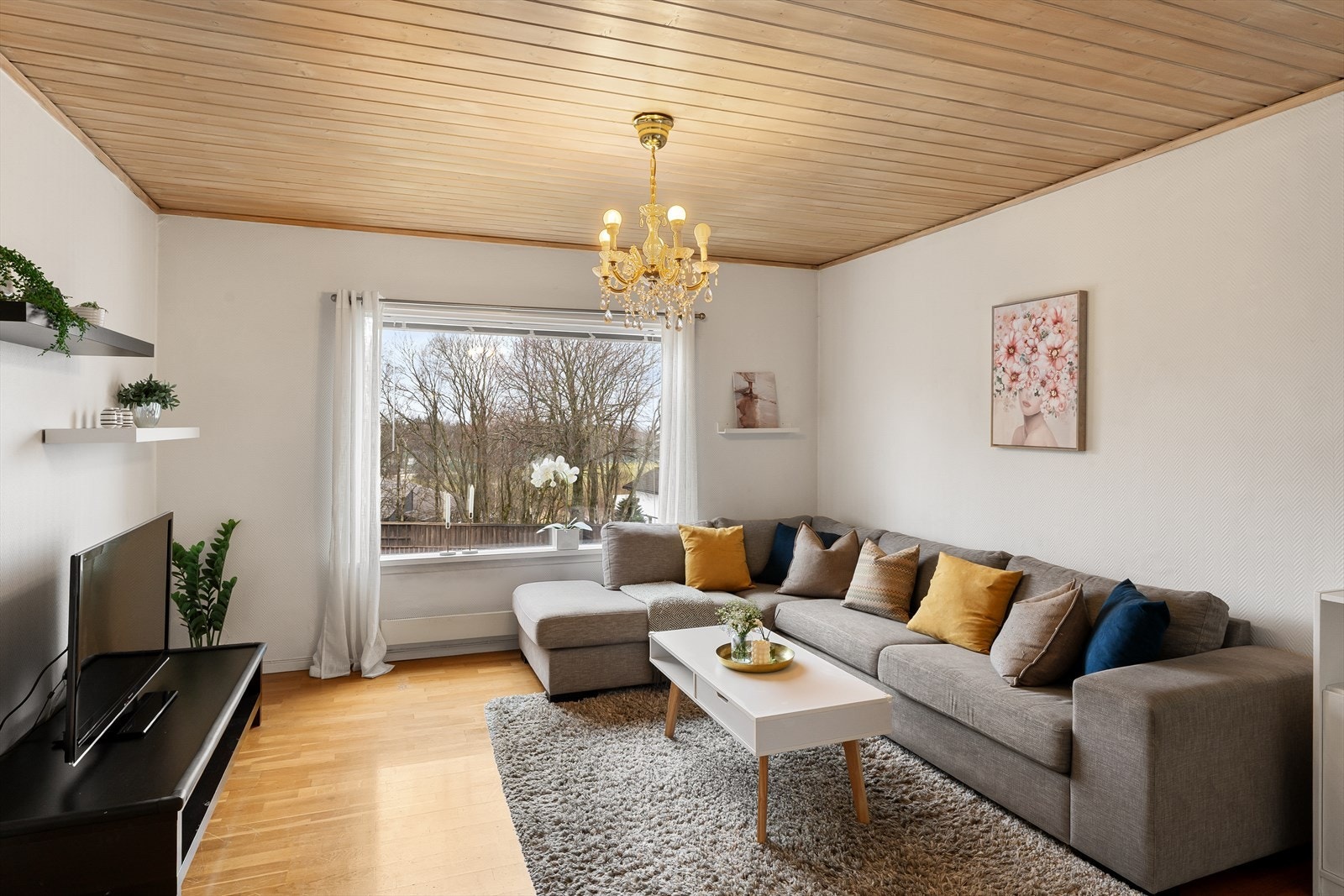 Lys, fin stue med stort vindu som slipper til rikelig med naturlig lys Galleribilde