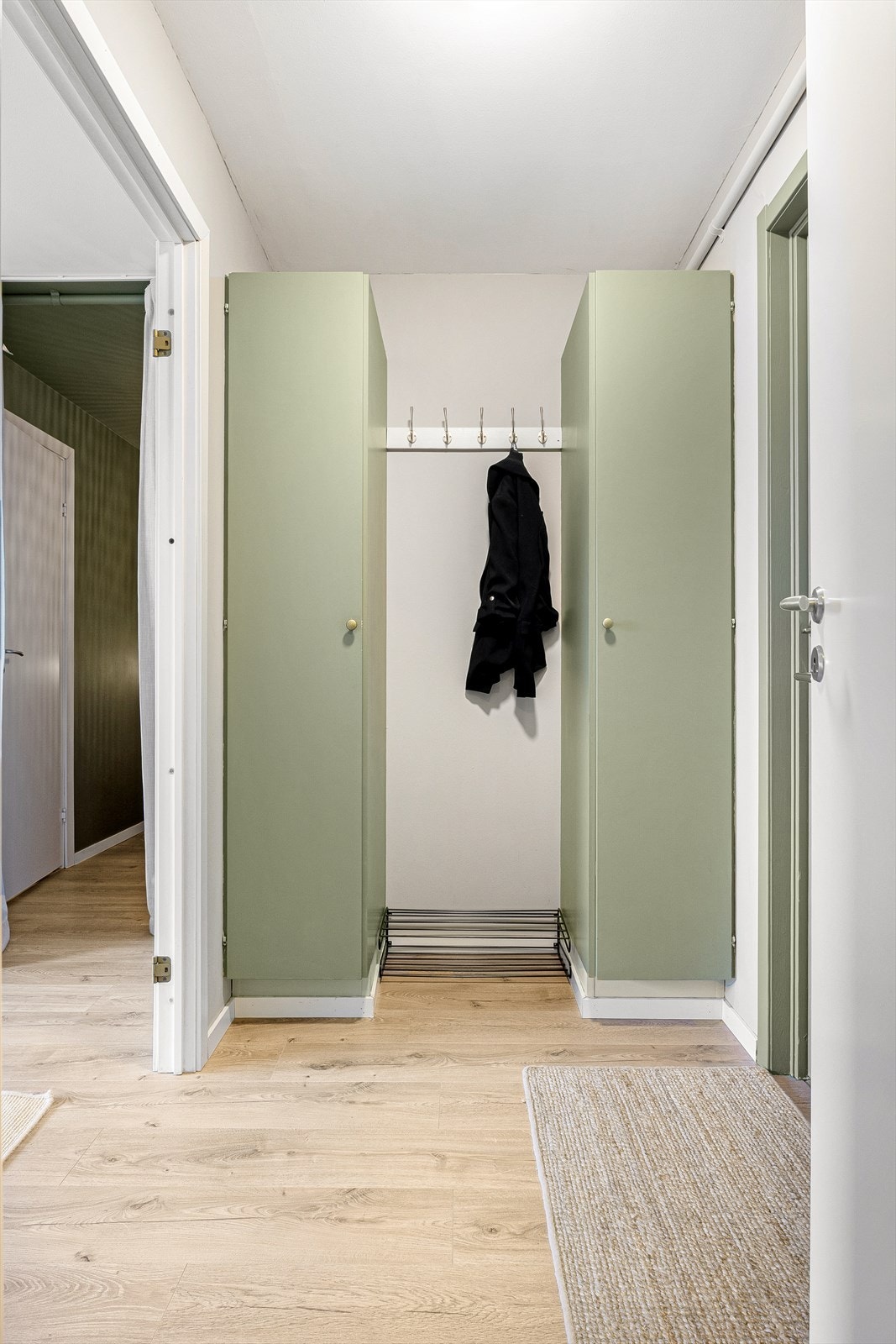 Garderobeskap på hver side med knaggoppheng imellom. Galleribilde
