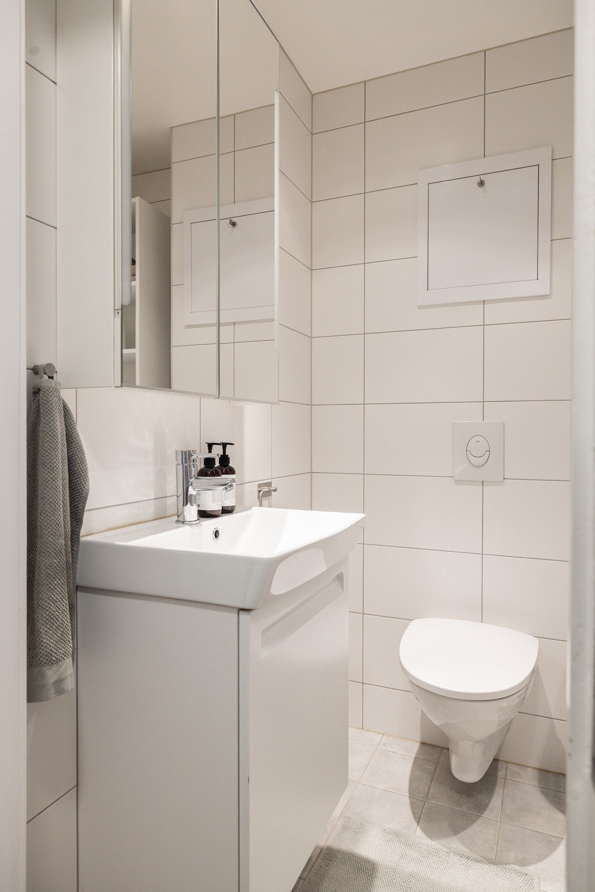 Badet har tidløs innredning med vegghengt toalett og smart speilskap. Varmekabler på gulvet. Galleribilde