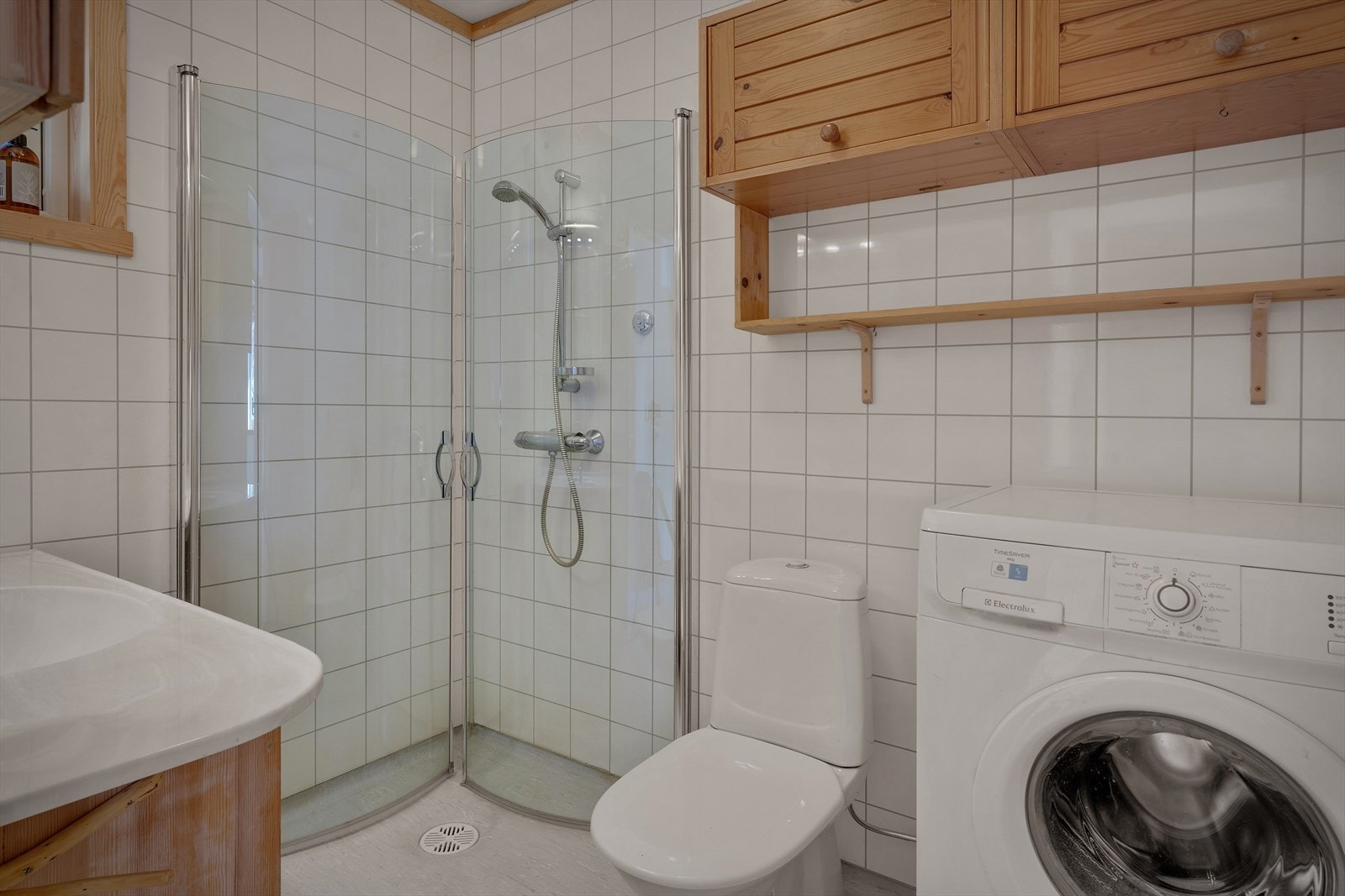 Pent bad med vinylbelegg på gulvet og baderomsplater på veggene. Galleribilde