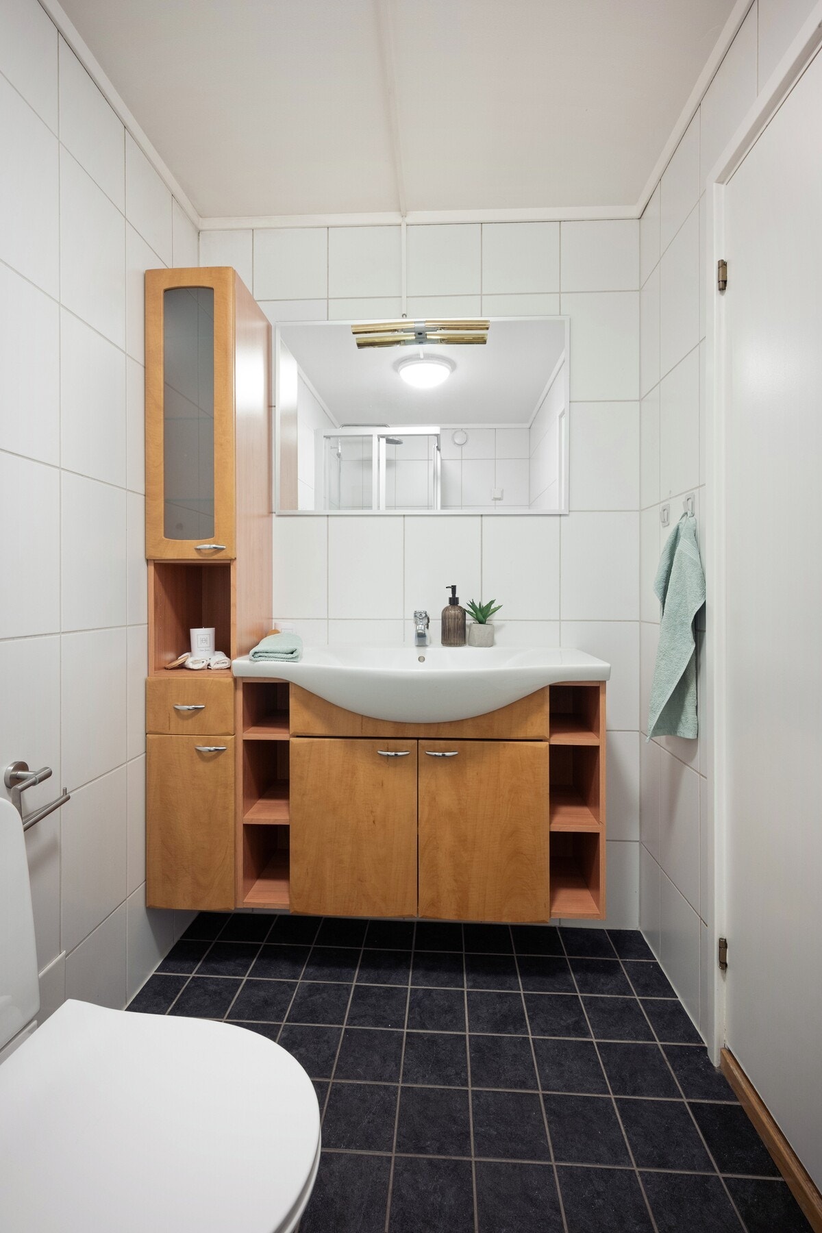 Flislagt bad med lyse vegger og mørkere gulv som gir et tidløst uttrykk. Badet har også varmekabler. Galleribilde