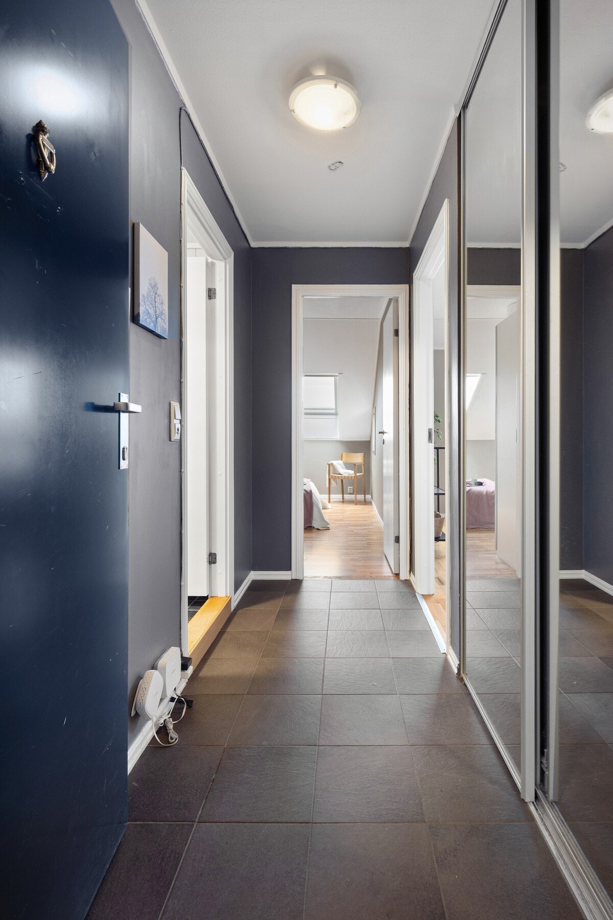 Boligen har en romslig og innbydende entré med god plass til oppbevaring av yttertøy og sko i skyvedørsgarderobe. Gulvet er flislagt, noe som gir et praktisk inngangsparti. Galleribilde