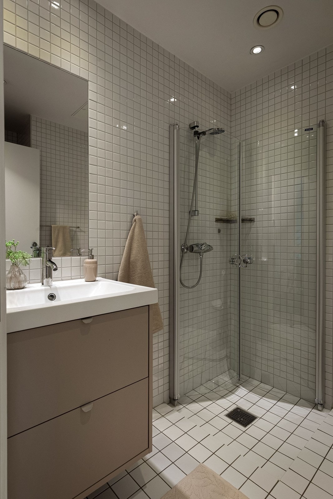 Badet er utstyrt med gulvstående toalett, dusjhjørne med innfellbare glassvegger og en 60 cm servant med skuffer, fornyet i 2025. Galleribilde