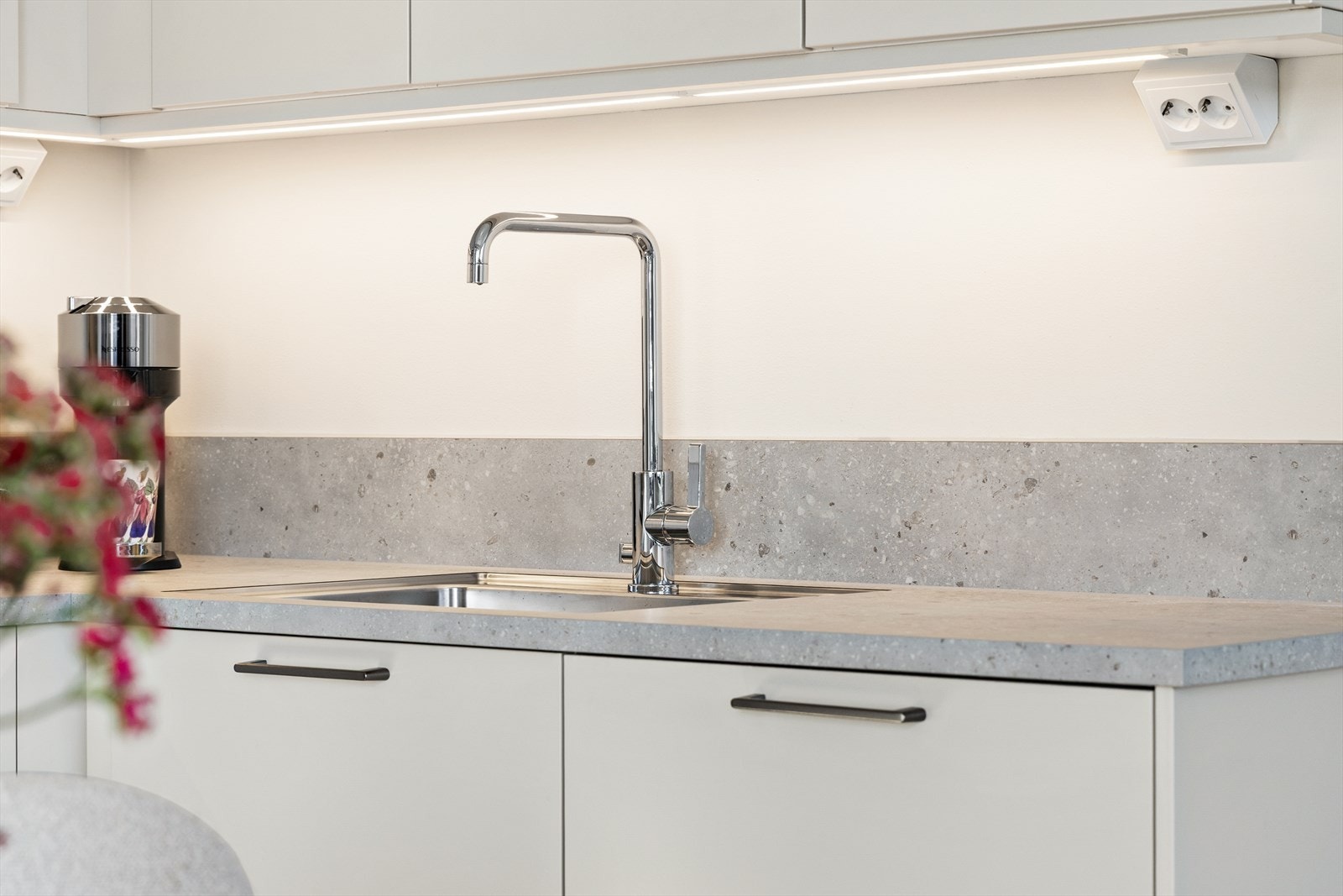 Kjøkkeninnredning med slette fronter og god arbeidsbelysning under overskapene. Galleribilde