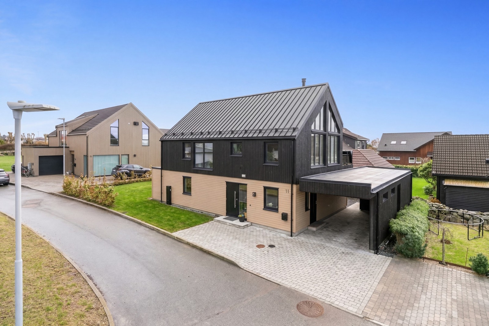 Boligen ligger i et barnevennlig område med lite trafikk og nærhet til lekeplasser (gressplen og gårdsrom er illustrert). Galleribilde