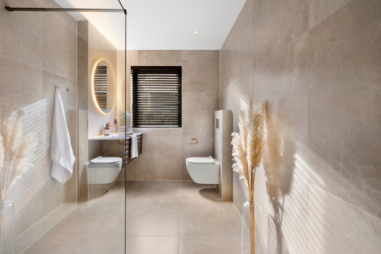 Badet i første etasje har et delikat preg med store fliser i en lun beigetone. Galleribilde