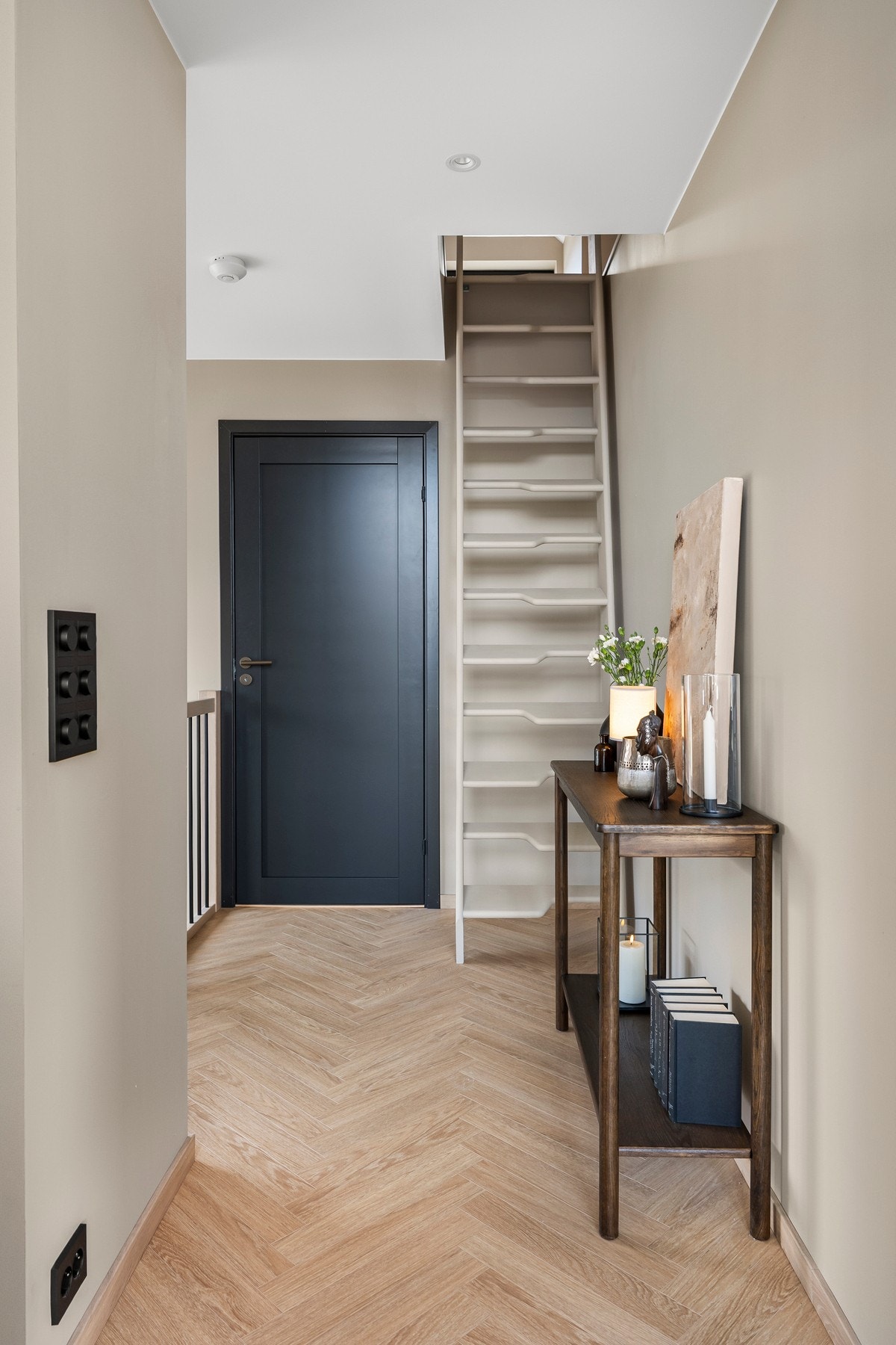 Fra stuen er det adkomst til boligens suitedel og loftsetasje. Trappen er malt i samme farge som veggen, og kan skyves helt inntil veggen for sparing av plass når loftet ikke er i bruk. Her er det også muligheter for å sette inn loftsluke om ønskelig. Galleribilde