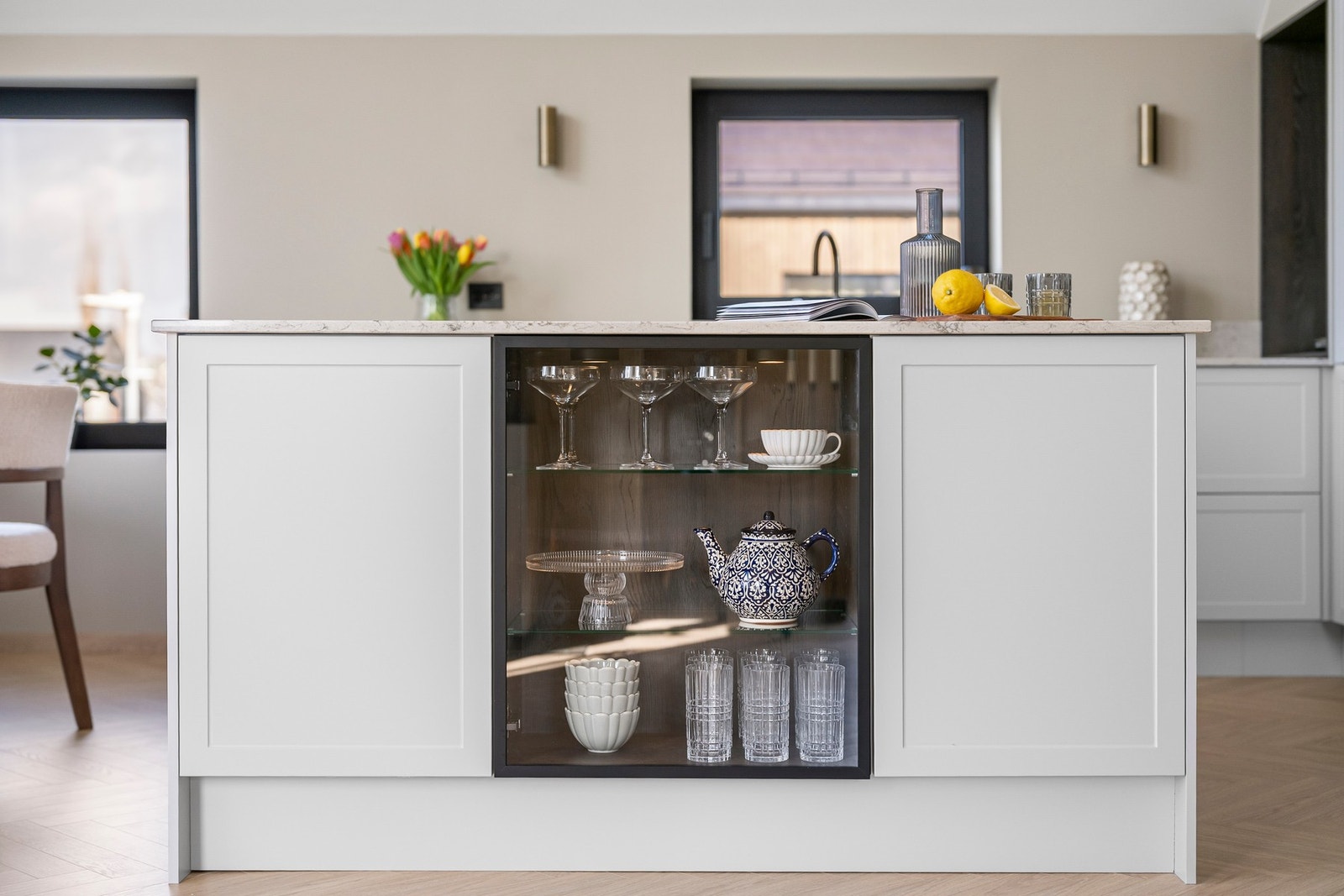 Kjøkkenøya har et innebygd vitrineskap med belysning som skaper et elegant blikkfang i rommet. Galleribilde