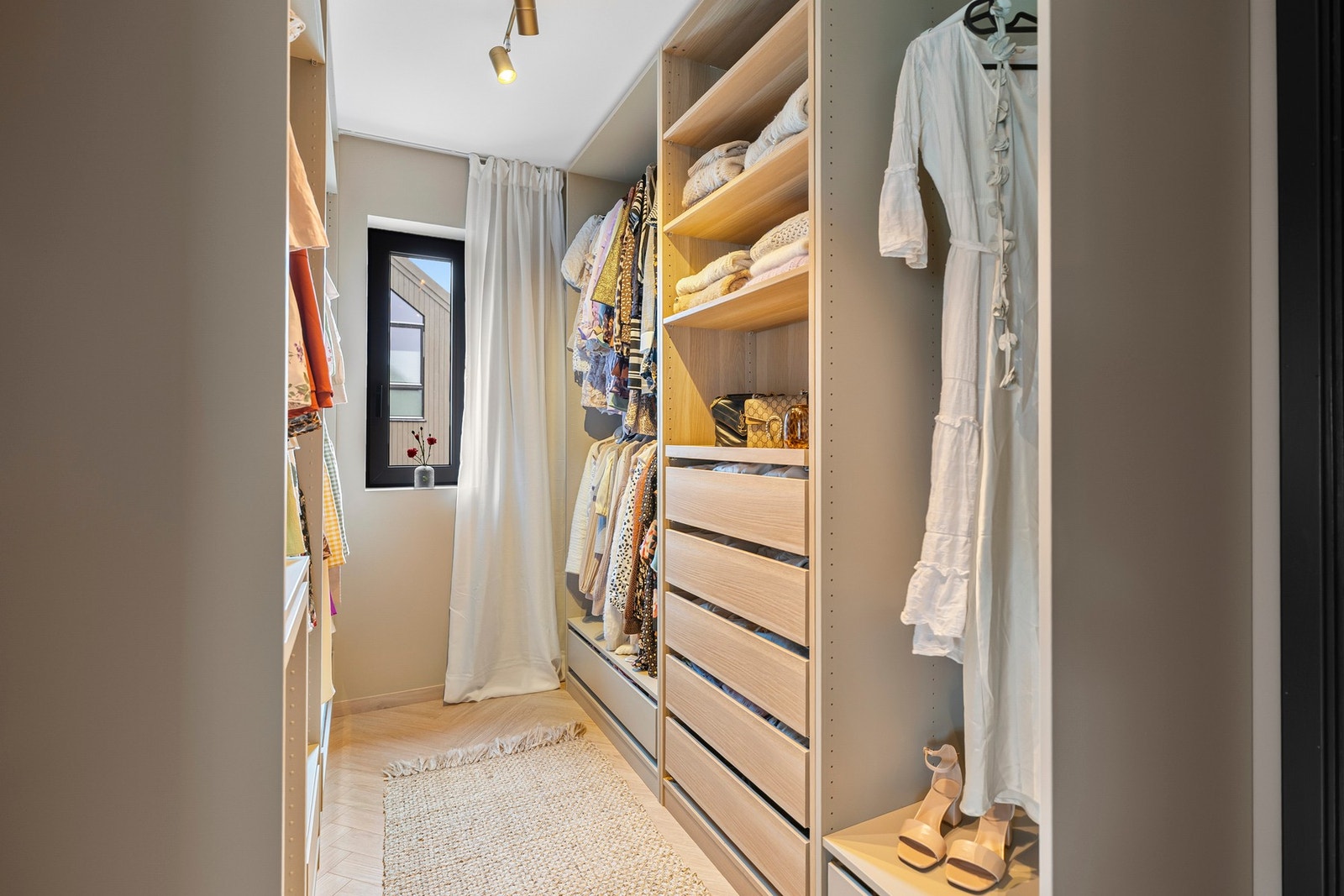 Romslig walk-in garderobe med gode oppbevaringsløsninger som gir en følelse av luksus i hverdagen. Galleribilde