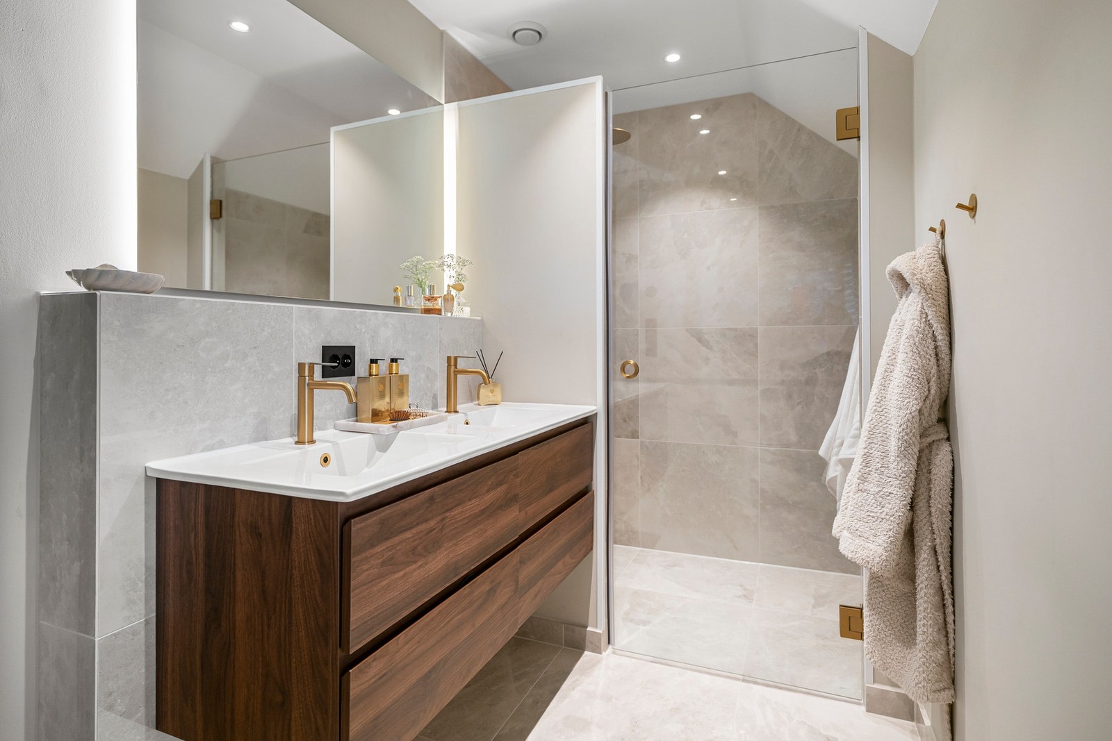 Badet tilhørende suiteløsningen er delikat utformet med stor regnfallsdusj og eksklusivt flisevalg. Galleribilde