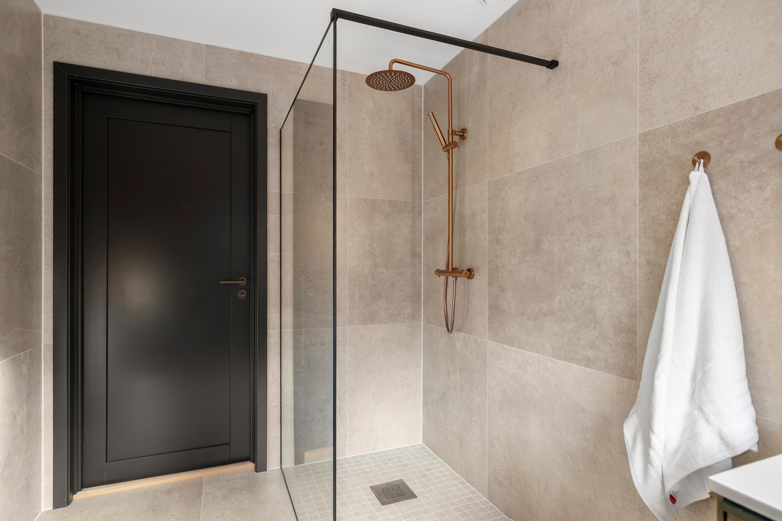 En romslig regnfallsdusj og behagelig gulvvarme gir badet en eksklusiv spa-lignende atmosfære. Galleribilde