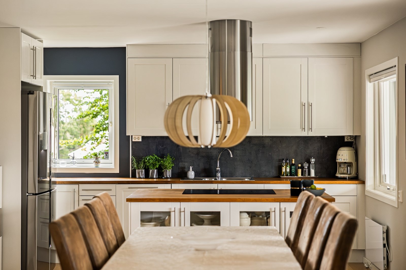 Løsningen inkluderer en praktisk kjøkkenøy, og det er rikelig med både benke- og skapplass. Galleribilde