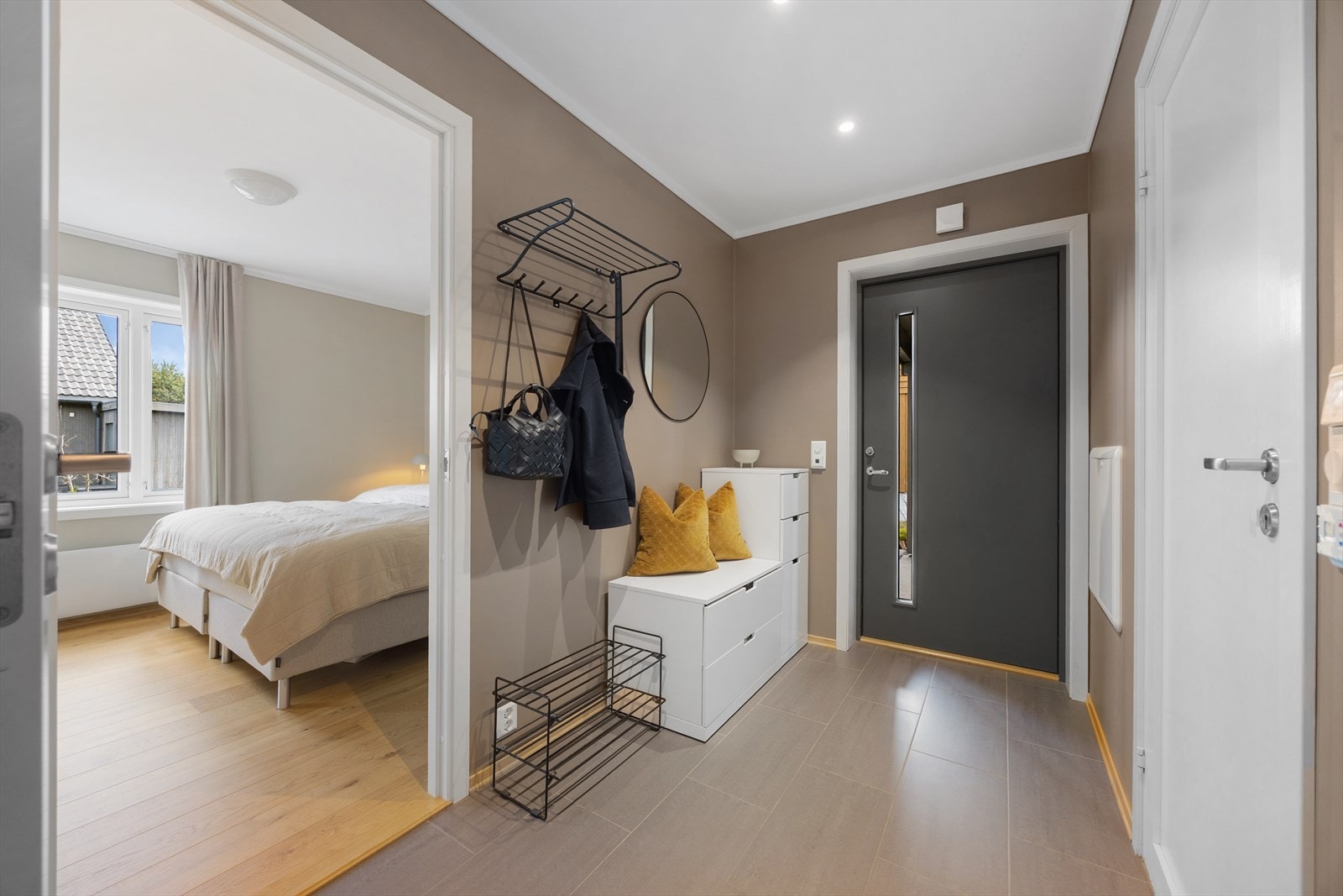 Romslig og delikat entré som ønsker velkommen inn i boligen! Her er det god plass til å sette fra seg sko og henge fra seg yttertøy. Galleribilde