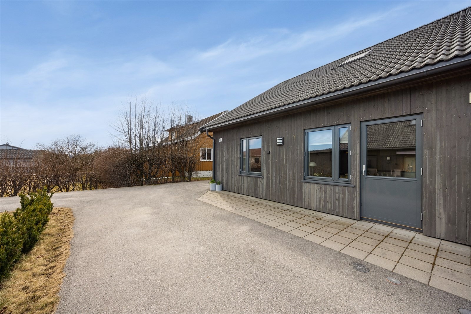 Mot gårdsplassen er det kjøkkenutgang hvor det er lagt betongheller inntil veggen. Galleribilde