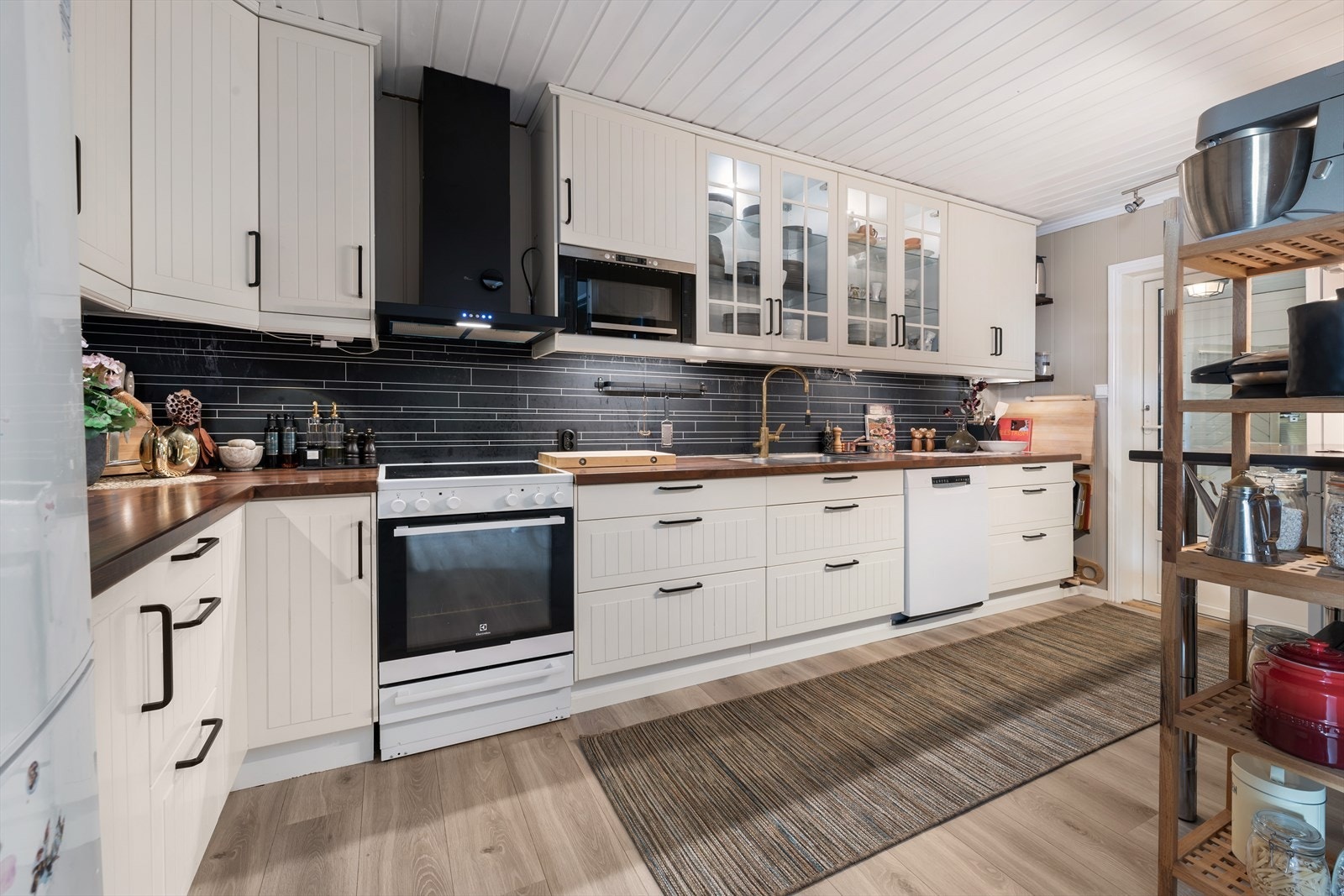 Kjøkkenet er utstyrt med laminerte profilerte fronter og laminert benkeplate med nedfelt oppvaskkum i stål. Galleribilde