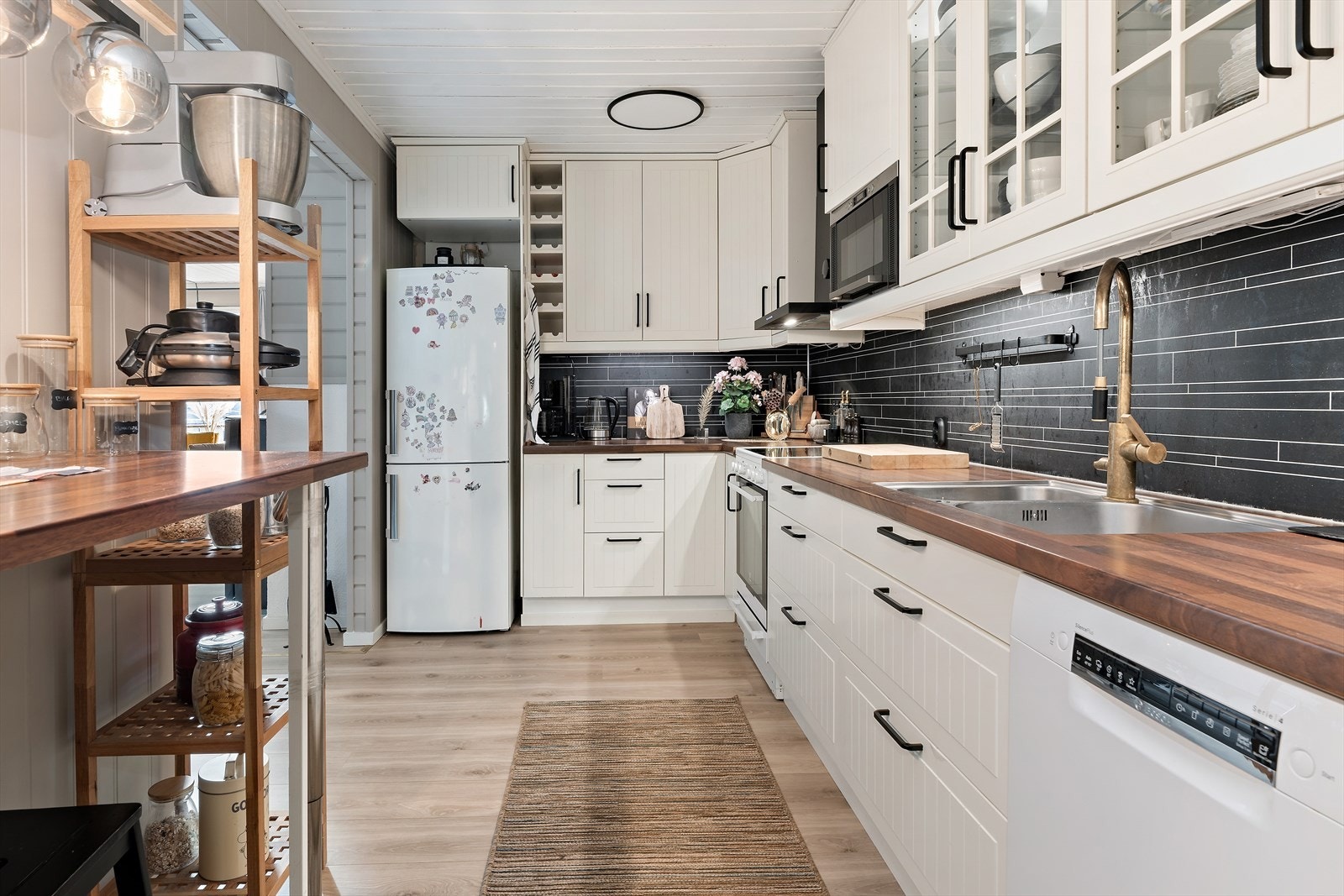 Kjøkkenet har frittstående hvitevarer, inkludert komfyr, kjøl/fryseskap og oppvaskmaskin, samt integrert mikrobølgeovn. Galleribilde