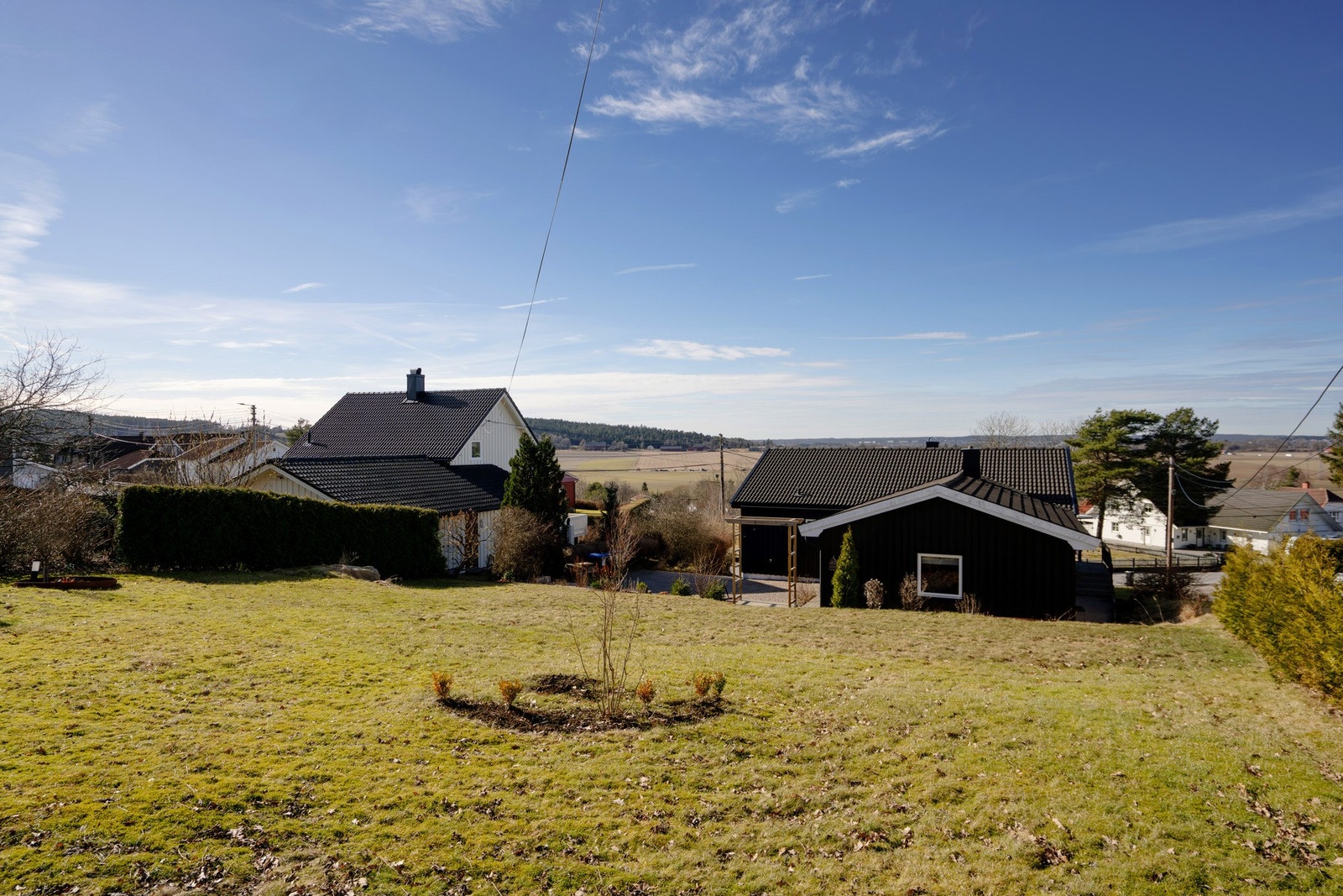 Eiendommen har stor gressplen på baksiden, og opparbeidet gårdsplass på fremsiden. Tomten er opplyst å være 1078 m2. Galleribilde