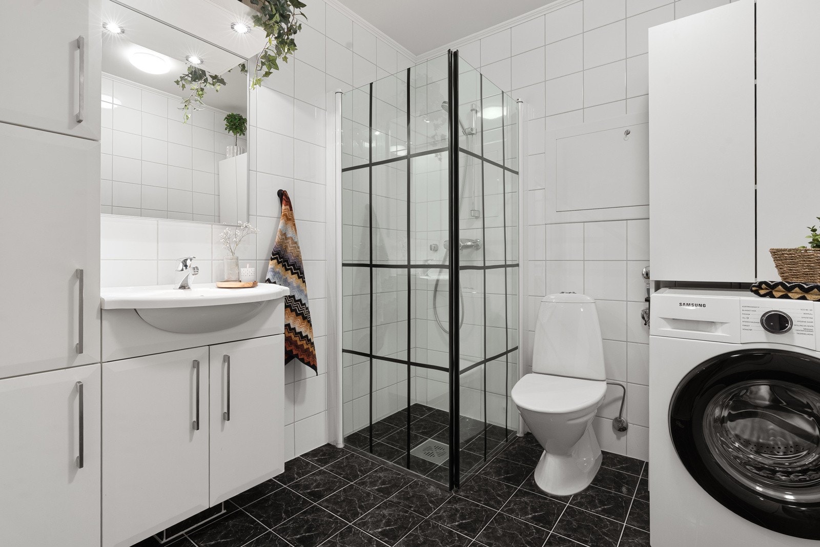 Lyst og flislagt bad med varme i gulv, opplegg for vaskemaskin samt dusjhjørne. Galleribilde