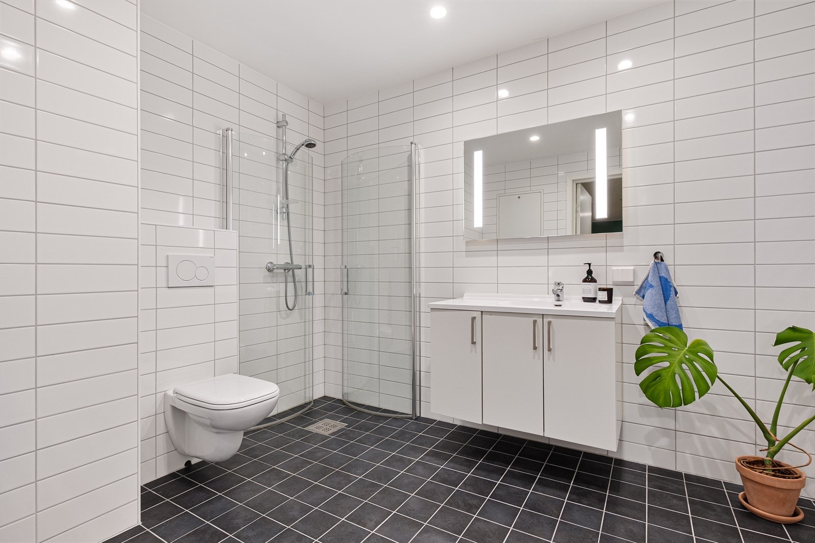 Badet er helfliset og fremstår som moderne og pent, med varmekabler i gulvet og innfelte downlights i himlingen som gir en behagelig belysning. Galleribilde