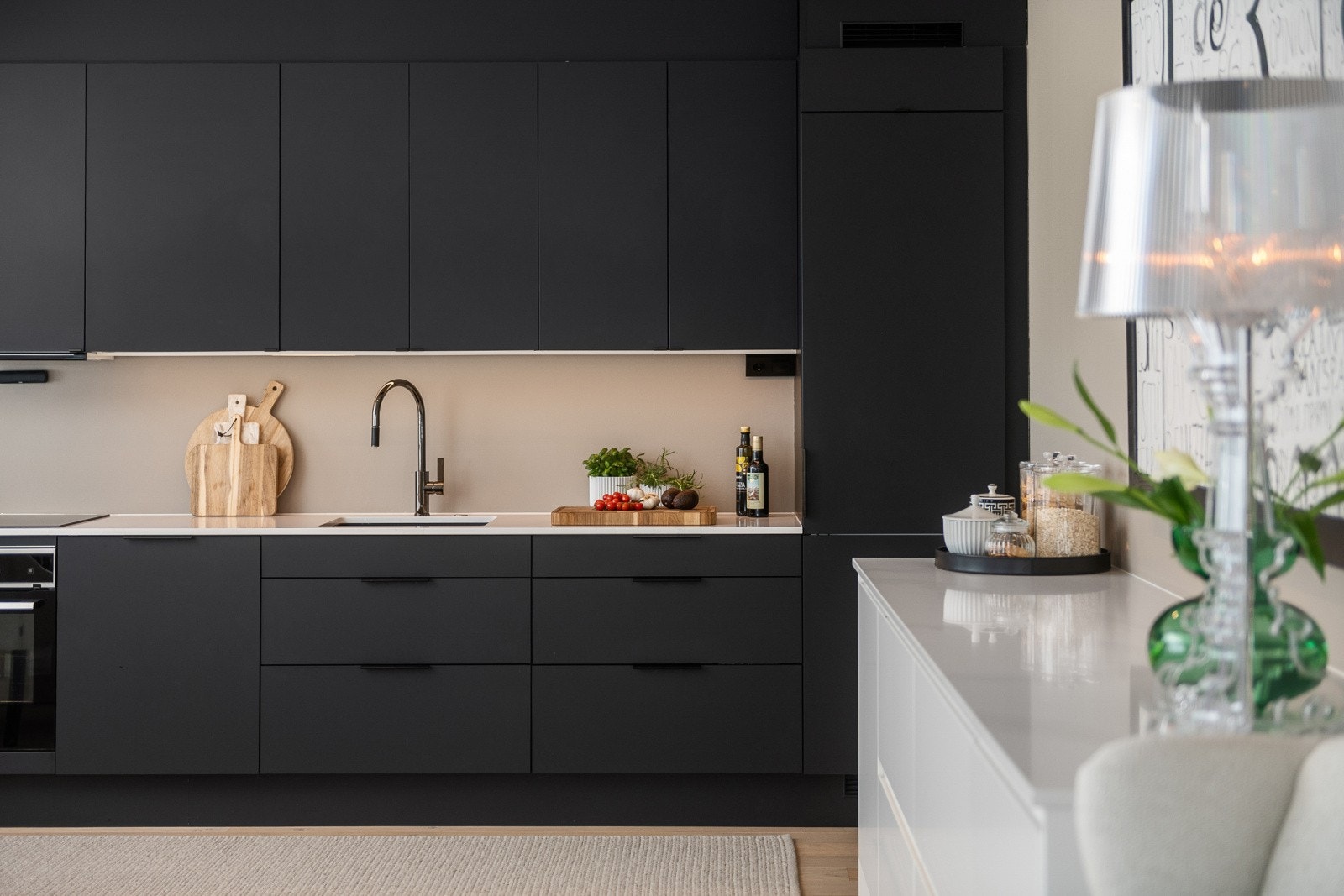 Stilrent og moderne kjøkken med mørke, slette fronter og integrerte hvitevarer. Galleribilde