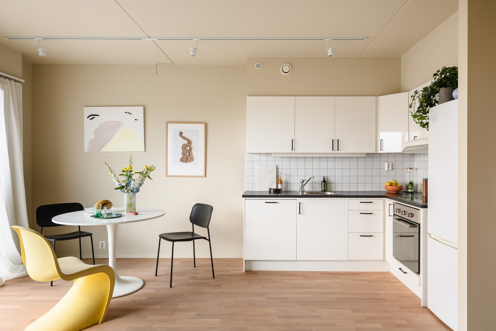 Stilrent kjøkken med integrerte hvitevarer og rene linjer. Fliser over benken og god arbeidsflate gjør rommet både praktisk og estetisk. Galleribilde