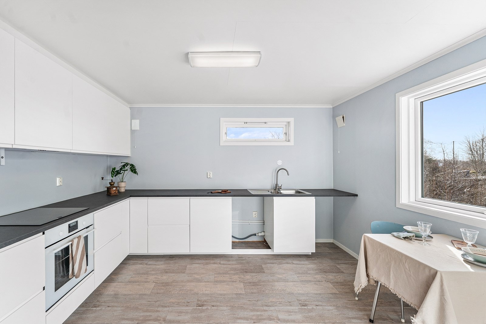 Kjøkkenet er modernisert i nyere tid og har slette fronter og benkeplate av laminat Galleribilde