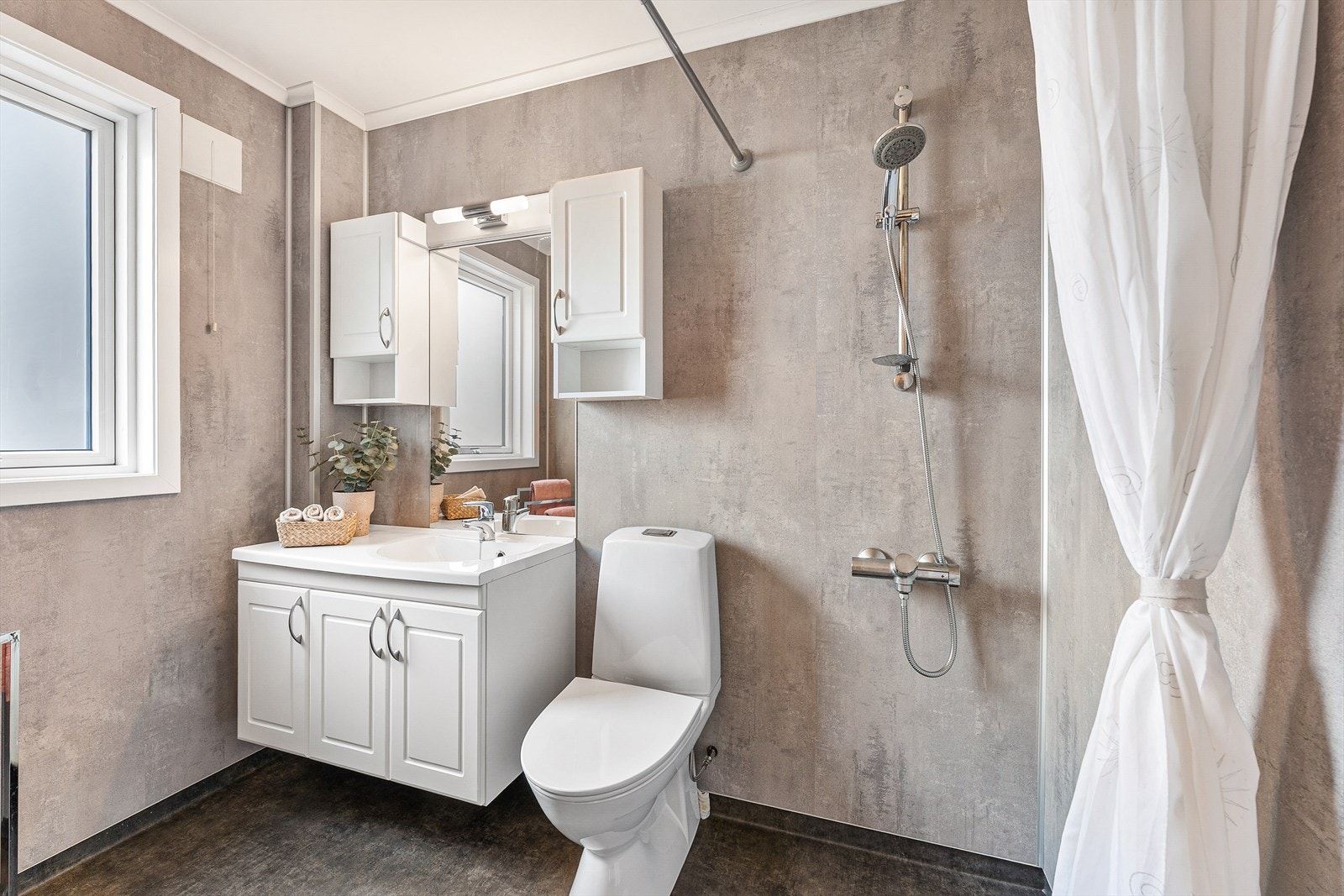 Badet i kjelleretasjen ble modernisert i 2020 og er innredet med toalett, servant og dusjhjørne Galleribilde