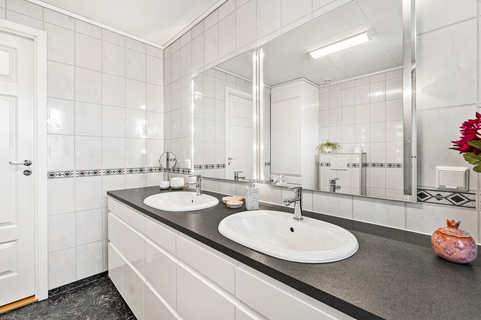 Badet er innredet med dobbel servant, dusjkabinett og veggmontert toalett Galleribilde